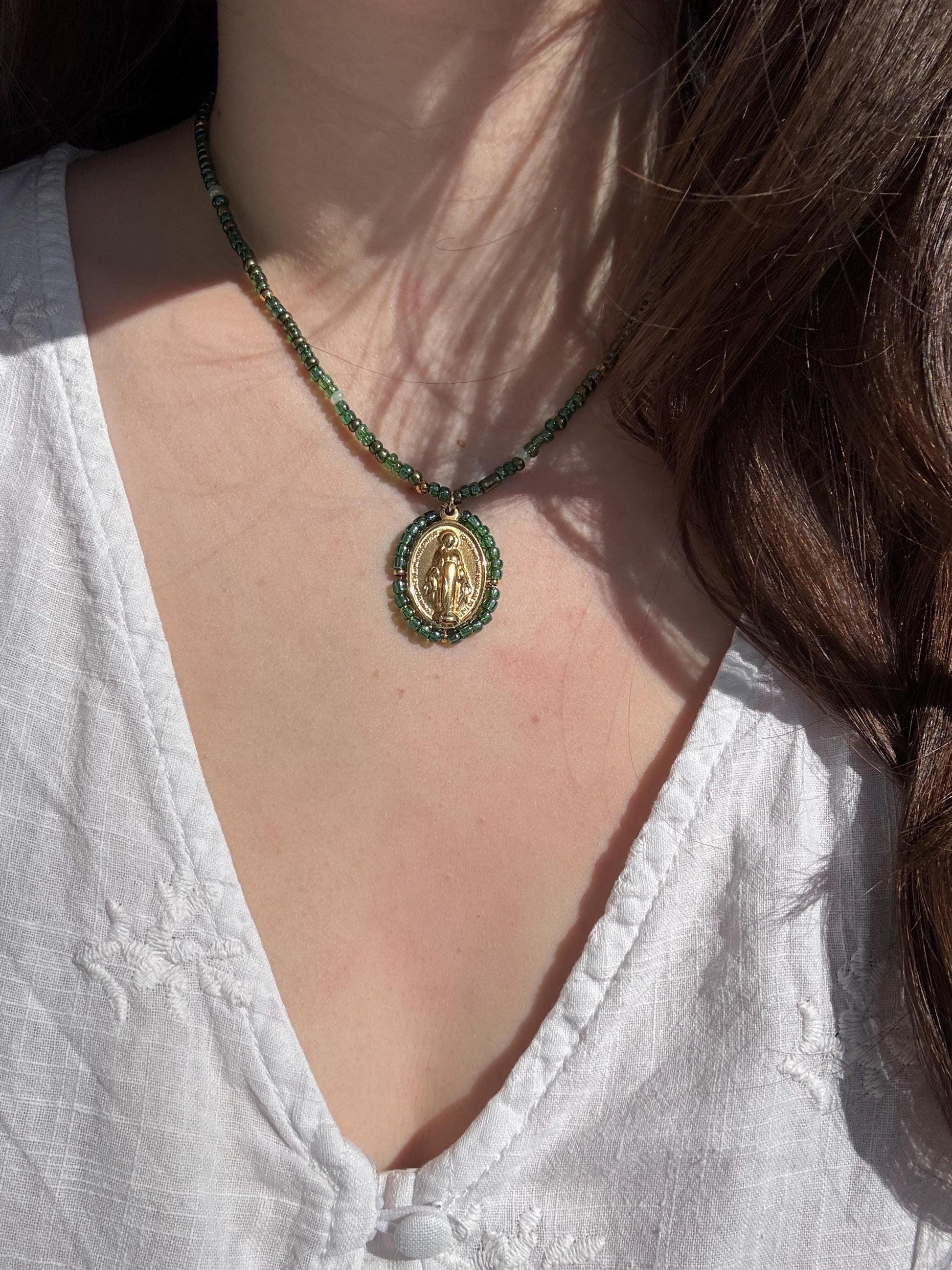 Femme portant un collier Médaille Miraculeuse perlée verte au quotidien
